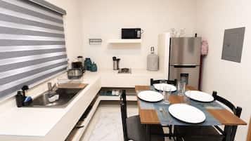 A compact kitchen with a microwave, sink, and refrigerator.
