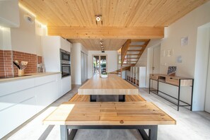 Eine moderne Küche mit Kochinsel, Holzboden und Blick ins Esszimmer.
