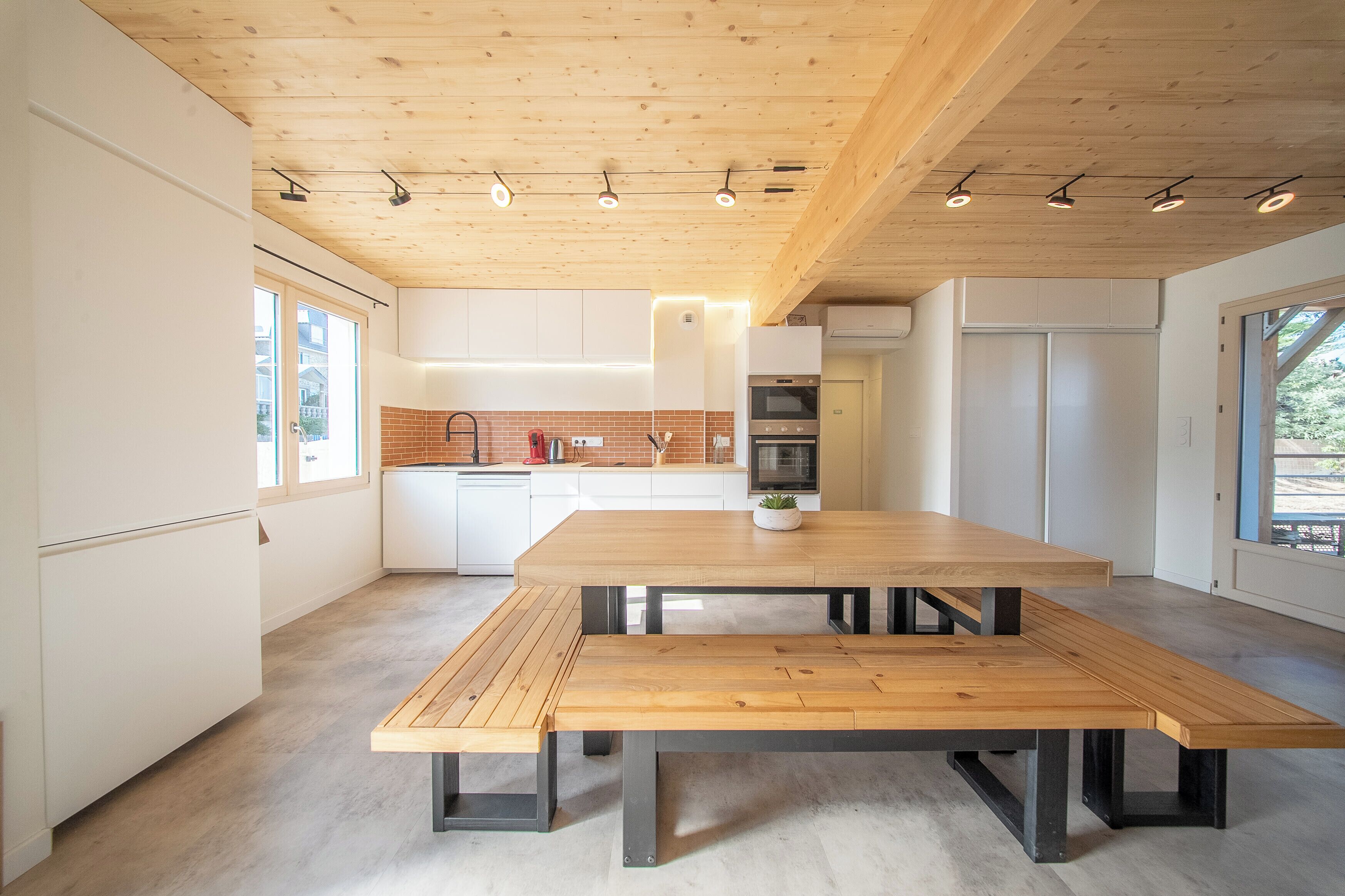Eine moderne Küche mit einem Holztisch und Schränken.