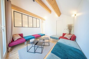 Ein modernes Wohnzimmer mit einem Ecksofa, einem Couchtisch und einem großen Fenster.