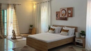 Un dormitorio con una cama de madera, una mesita de noche, una lámpara de pared y un aplique de techo.