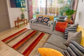 A living room with a grey sofa, a striped rug, and a potted plant. - Perfect Getaway among the Pucón Forests (Pucon)
