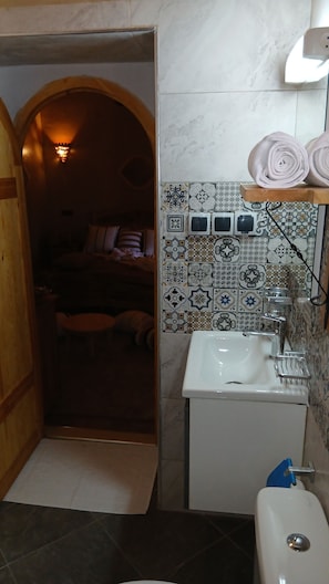 Un baño con lavamanos, inodoro y zona de ducha.