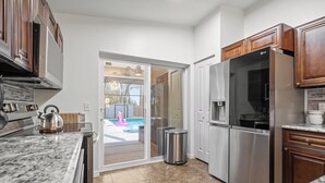 A kitchen with a stainless steel refrigerator, a microwave, and a kettle on the counter. - Heated Pool & SPA Retreat+Gameroom+ Beaches+IMG (Bradenton)