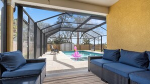 A covered outdoor area with a pool, two sofas, and a patio. - Heated Pool & SPA Retreat+Gameroom+ Beaches+IMG (Bradenton)
