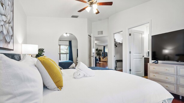 A bedroom with a large bed, a ceiling fan, a TV, and a dresser. - Heated Pool & SPA Retreat+Gameroom+ Beaches+IMG (Bradenton)