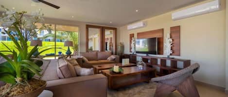Una sala de estar moderna con un sofá, una mesa de centro y una televisión.