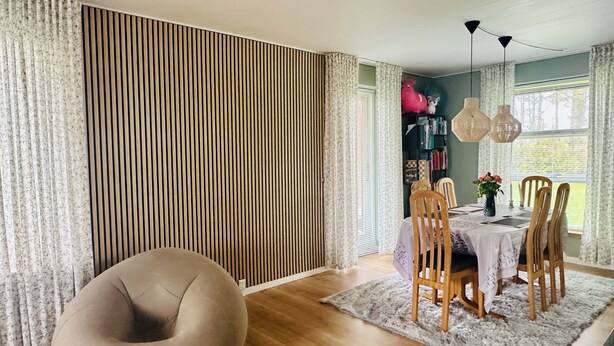 A dining area with a table, chairs, a bean bag, a bookshelf, and a window with curtains. - Family private house 4-5 rooms (Brovst)