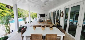 A covered patio with a dining table, chairs, and decorative pottery.