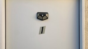 Una porta blanca amb un distintiu amb el número 1, una ranura per al correu i una clau.