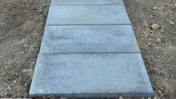 Un camí de formigó que condueix a una entrada de maó.