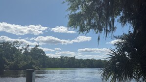 A wooden dock extending into a calm lake surrounded by dense trees and a clear sky. - Terrific camping site inSatsuma perfectfor your outdoor adventure.Near the river (Satsuma)