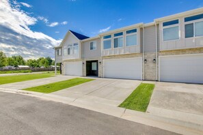 A two-story residential building with a garage, a covered patio, and a well-maintained lawn. - Updated Garden City Retreat <1 Mi to Bear Lake and walking distance to stores! (Garden City)