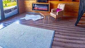 Tunnelmallinen huone, jossa on takka, televisio ja mukava nojatuoli.