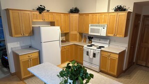 Una cucina con mobili in legno, un frigorifero, un forno a microonde e un forno.