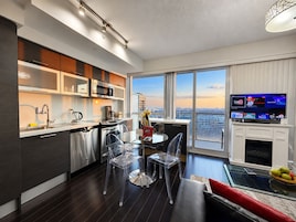 Una cocina moderna con comedor, ventanas amplias y un televisor de pantalla plana.