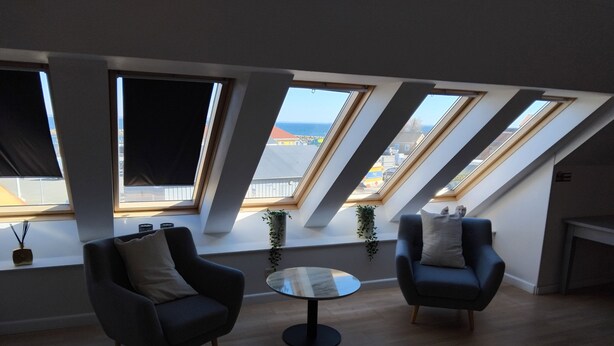 A modern living room with skylights, two armchairs, a round coffee table, and a fireplace. - Holiday apartment by the coast on Ærø (Søby Ærø)