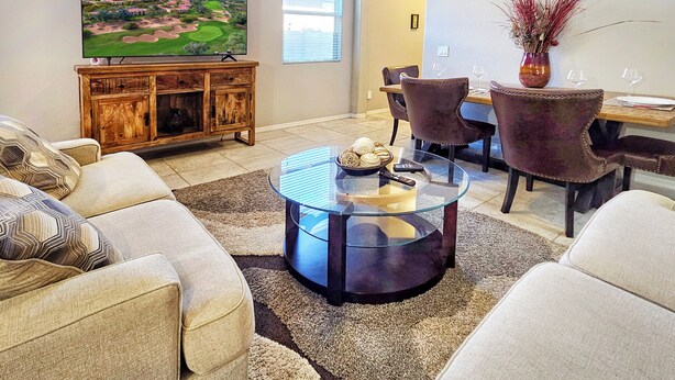 A living room with a TV, sofa, coffee table, and dining area. - Spacious Desert Suite - Minutes to Phoenix Fun - Pet Friendly! (Avondale)