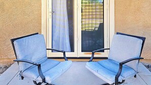 A patio with two chairs and a sliding glass door. - Spacious Desert Suite - Minutes to Phoenix Fun - Pet Friendly! (Avondale)