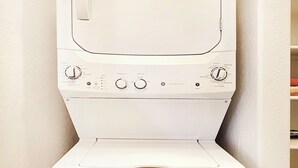 A white washing machine with a control panel, located in a corner of a room with a tiled floor. - Spacious Desert Suite - Minutes to Phoenix Fun - Pet Friendly! (Avondale)