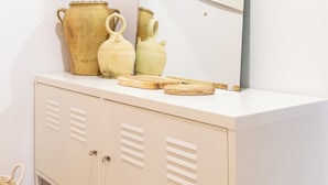 A white vanity with a mirror, two ceramic pots, and a woven basket. - Studio 2 bedrooms for climbers in ALBARRACIN | FREE WIFI (AR)