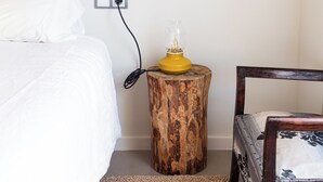 A bed with white bedding, a wooden nightstand with a yellow lamp, and a chair with patterned upholstery. - Studio 2 bedrooms for climbers in ALBARRACIN | FREE WIFI (AR)