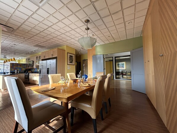 Una cocina moderna con comedor, suelo de madera y techo con diseño de cuadrícula.