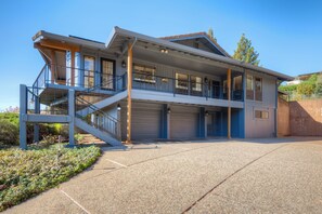 Une maison à deux étages avec un balcon, un garage et une allée.