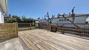 A wooden deck with a wooden fence, a trash bin, and houses in the background. - Saint-Palais-sur-Mer – BRIGHT HOUSE – a relaxing escape between sea and nature (ST PALAIS SUR MER)