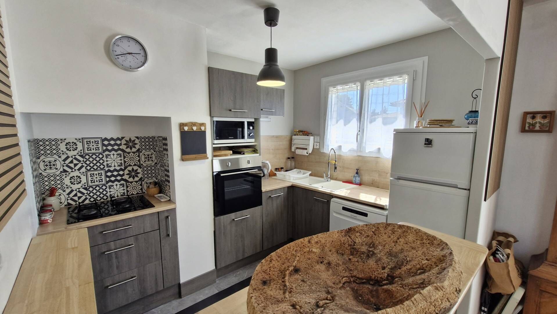 A compact kitchen with a gas stove, microwave, oven, and a refrigerator.