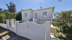 A two-story house with a white exterior, a gated entrance, and a mailbox. - Saint-Palais-sur-Mer – BRIGHT HOUSE – a relaxing escape between sea and nature (ST PALAIS SUR MER)