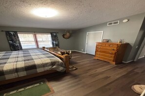 Ein Schlafzimmer mit Bett, Schminktisch und einem an der Wand befestigten Hirschkopf.