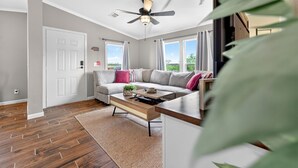 Un salon moderne avec un canapé, une table basse et un ventilateur de plafond.