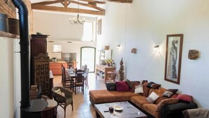 A spacious living area with a sofa set, dining table, and a kitchen in the background. - Le Boucaou - SABONNERES (SABONNERES)