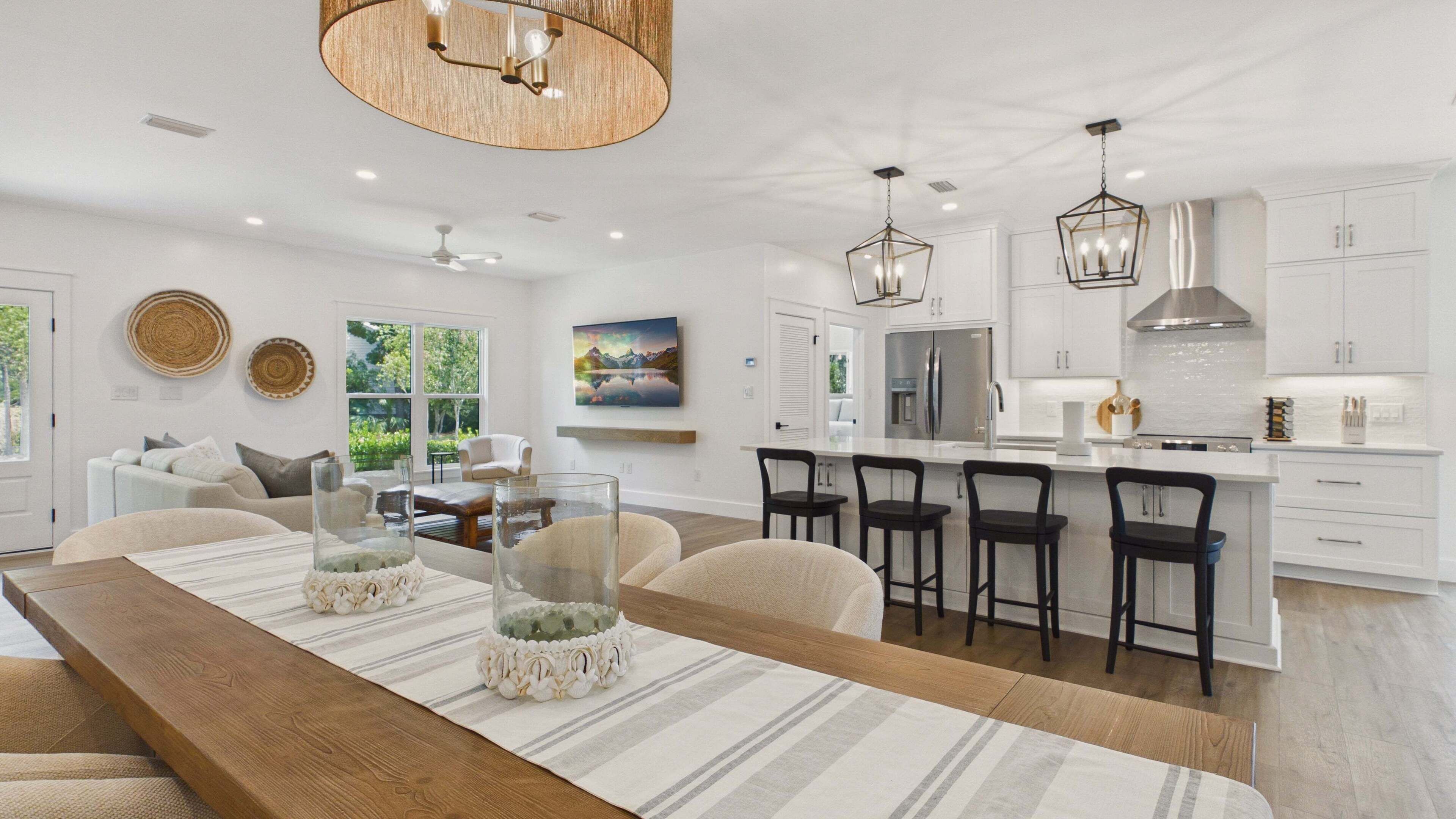 A modern kitchen with white cabinets, stainless steel appliances, and a central island with bar stools.