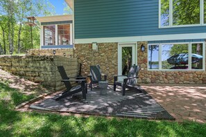 A stone wall, outdoor seating area with chairs and a table, and a house with large windows. - Come relax at your home away from home walking distance to downtown Boulder! (Boulder Junction)
