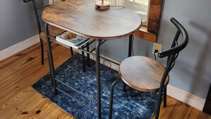A round wooden table with metal chairs, a lamp, and a rug. - Tiny House on Century Farmstead (Muskego)