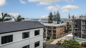 Un hôtel à plusieurs étages doté d’une piscine, offrant une vue sur l’océan et disposant d’un parking.