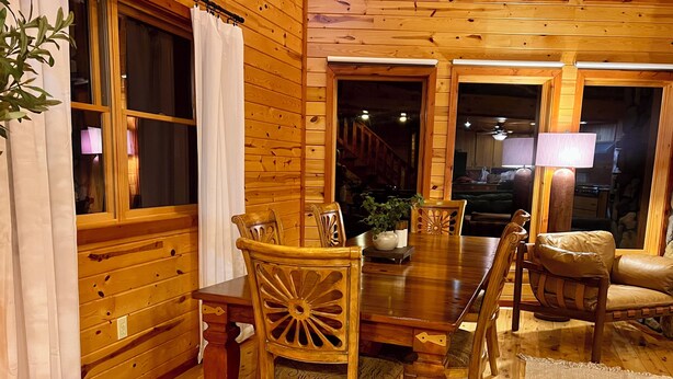 A wooden interior with a dining table, chairs, and a lamp. - Maxwell Reserve • Private Forest Retreat • Sleeps 14 (Tionesta)