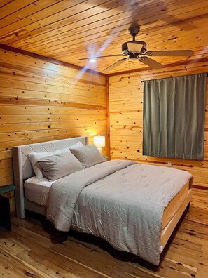 A room with a bed, a ceiling fan, and wooden walls. - Maxwell Reserve • Private Forest Retreat • Sleeps 14 (Tionesta)
