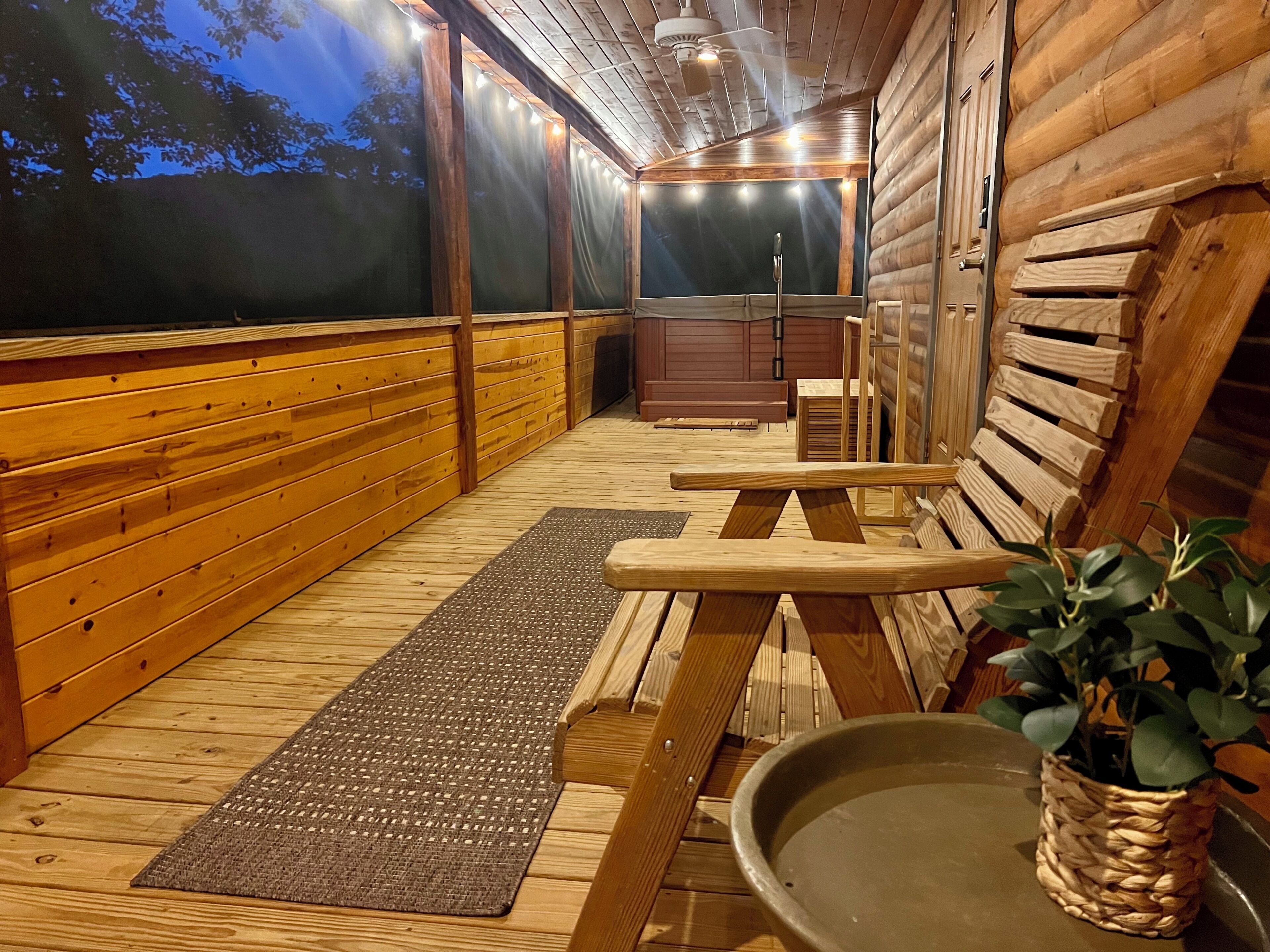 A wooden deck with a bench, a small table, and a potted plant.