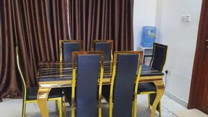 Ein Konferenzraum mit Marmorboden, einem Tisch mit Stühlen, einem Wasserspender und einer Klimaanlage.