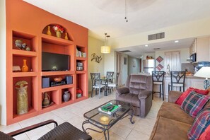 Ein Wohnzimmer mit Fernseher, Sofa und Couchtisch.