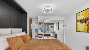 A bedroom with a large bed, a ceiling fan, and a cityscape painting. - Mile High Mid-Century Oasis, Light-Filled Central Denver Walkable Neighborhood!! (Denver)