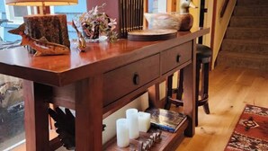 A wooden console table with decorative items, a lamp, and a view of a staircase.