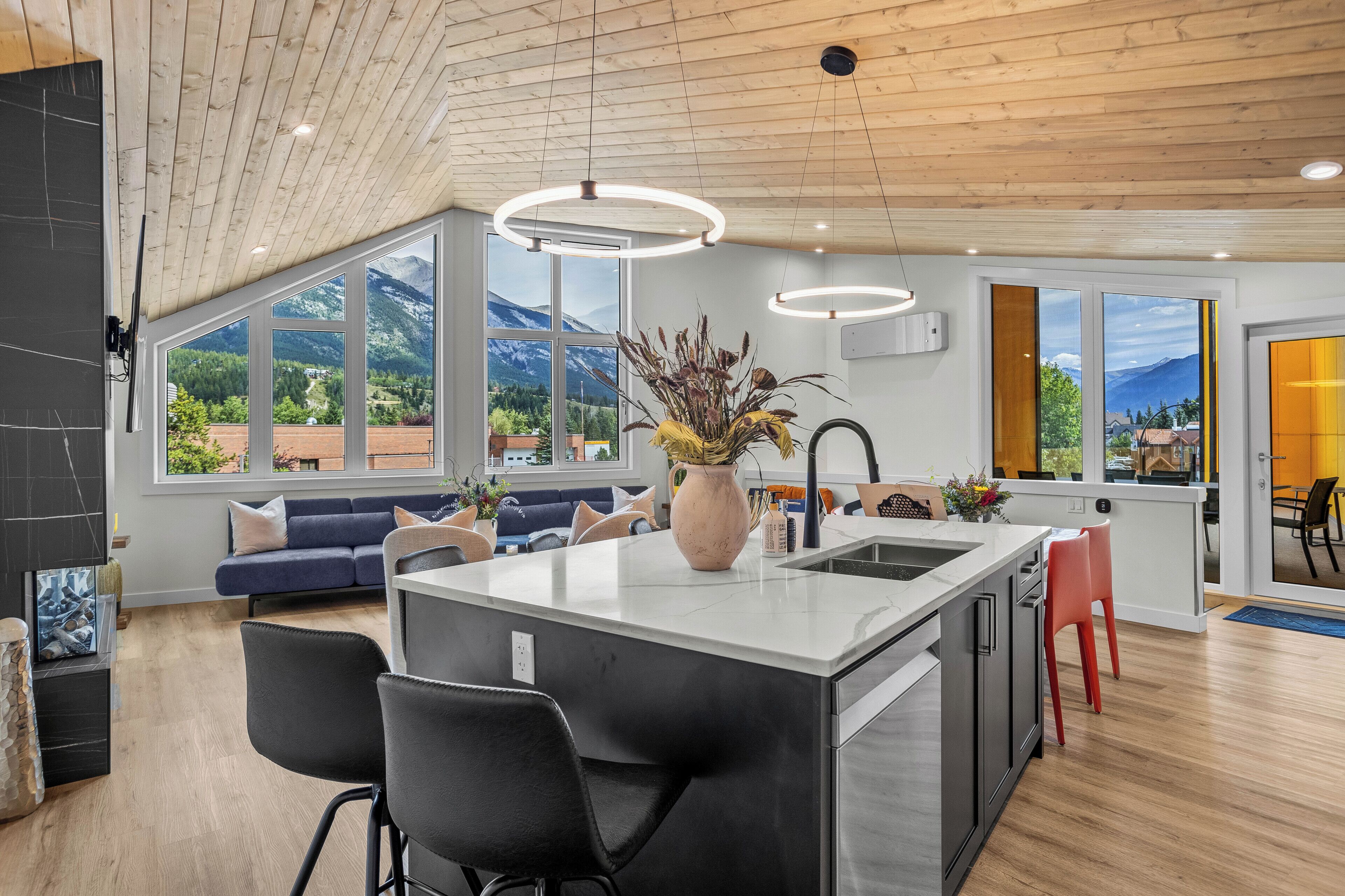 Sleek kitchen with island seating and panoramic windows.