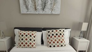 A neatly made bed with white bedding, two pillows with a polka dot pattern, and two folded towels. - WONDERFUL VILLA BY THE SEA (Anzio)