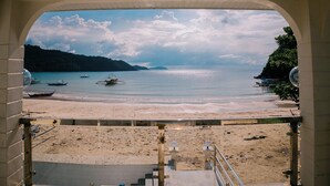 A beach view from a covered area with boats on the water and a staircase leading down. - Serene 8-bedroom resort with AC in beautiful El Nido (El Nido)