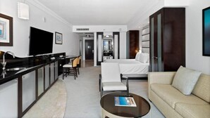 A modern hotel room with a kitchenette, a sofa, a dining area, and a large bed. - Sorrento 704 (Miami Beach)