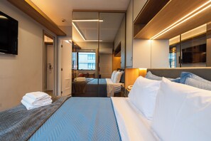 Ein Hotelzimmer mit Bett, Nachttisch und Fernseher.
